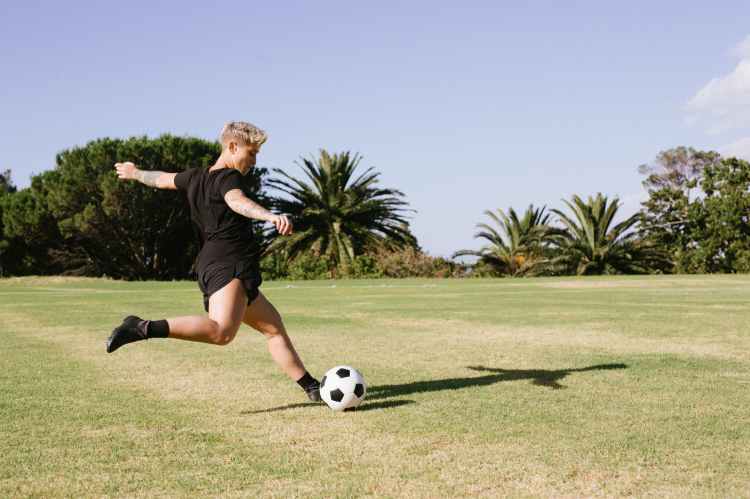 woman in black t shirt and black shorts playing soccer